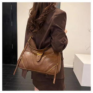 Detail of vintage dark brown tote bag with metal buckle and chain strap on shoulder