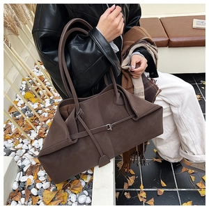 Detail of dark brown suede tote bag featuring a refined strap and matte leather texture
