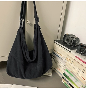 Grand sac bandoulière en toile noire avec texture vintage et sangle réglable en détail