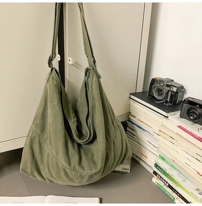Détail du sac bandoulière en toile verte avec coutures courbées en décor de vie