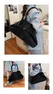 Detail view of a black large-capacity tote bag in matte suede with a minimalist metal buckle