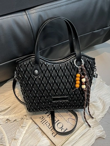 Chic black bucket bag with woven texture, wavy top edge and wood bead charm detail