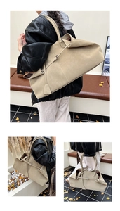 Close-up of a large beige suede tote bag with slim handles and a minimalist chic design