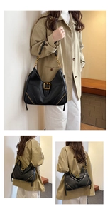 Detail view of black hobo bag with gold chain strap and decorative zipper accents