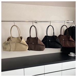 Hanging display of suede tote bags in beige, dark brown, black, and wine red colors