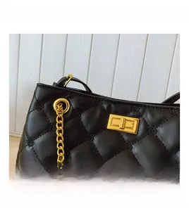 Detailed close-up of golden metal twist lock and quilted leather on the shoulder bag