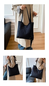 Detail view of reinforced leather corners and durable nylon fabric on a black tote bag