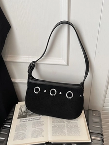 Sac sous le bras rétro en daim noir avec rivets argentés sur une valise chic