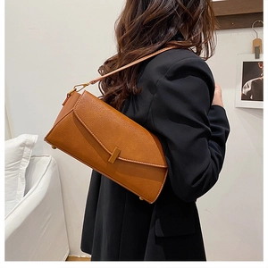 Détail d'un sac à bandoulière en cuir grainé beige avec boucle en métal doré