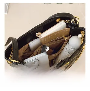 Interior view of brown quilted tote bag showing large capacity for umbrella and phone