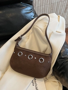 Sac sous le bras en daim marron vintage avec clous argentés sur un blazer
