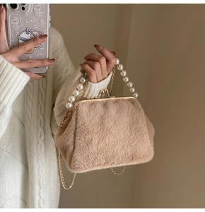 Detail der flauschigen braunen Bügeltasche mit Perlengriff und Goldkette