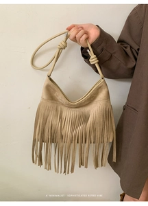 Détail du sac à franges en daim beige avec sangle à nœud et boucles argentées