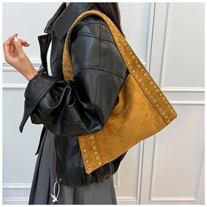 Close-up of vintage brown suede shoulder bag with decorative golden metal rivets