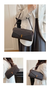 Détail d'un sac baguette en cuir grainé avec boucle dorée et surpiqûres blanches