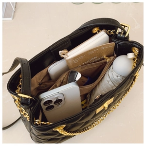Interior view of black quilted leather tote bag showing large capacity and compartments