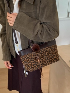 Retro leopard print tote bag with plush charm and leather straps shown on a model