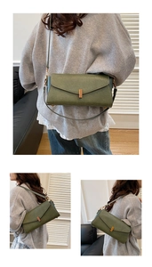 Détail du sac bandoulière en cuir vert foncé avec boucle métallique dorée minimaliste