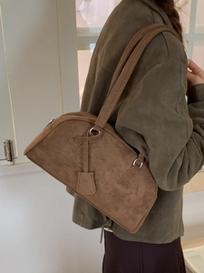 Brown faux suede shoulder bag with minimalist rectangular design and silver metal rings