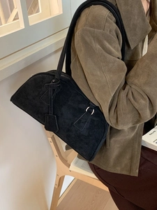 Minimalist black suede half-moon shoulder bag with sleek silver hardware and long strap