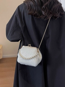 Weiße Kunstpelz Handtasche mit Perlengriff und Goldkette auf schwarzem Mantel gezeigt