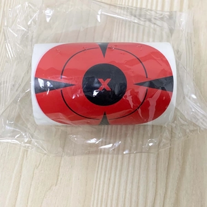 Detail of red and black archery splatter target stickers roll on wooden background