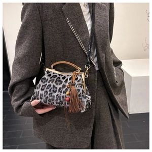 Détail du sac vintage imprimé léopard avec cadre en métal et breloque à franges brunes