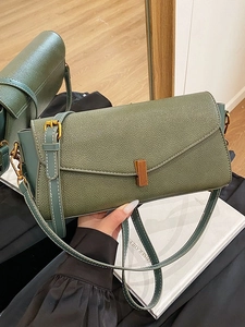 Sac bandoulière en cuir grainé vert avec fermoir doré et surpiqûres blanches contrastées