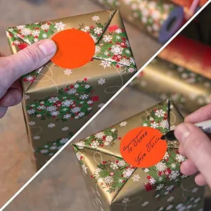 Etichette adesive arancioni tonde su regali di Natale con superficie scrivibile