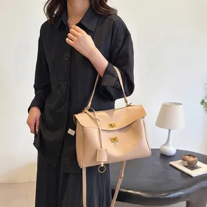 Elegant apricot leather tote bag with dual flap golden buckles and shoulder strap