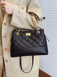 Classic black quilted leather tote bag with gold chain and adjustable shoulder strap