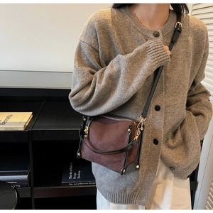Close-up of vintage quilted suede handbag with brown stitching and metallic twist lock