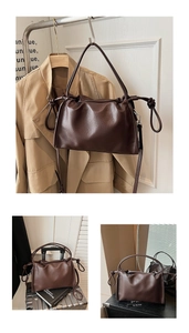 Detail of dark brown lychee leather handbag with knot handle and detachable shoulder strap