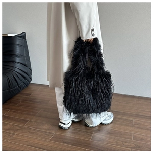 Detail of a black plush faux fur tote bag showing long fluffy texture and soft volume