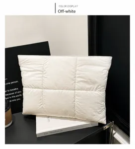Detail of cream quilted handbag showing plush texture and square stitching patterns