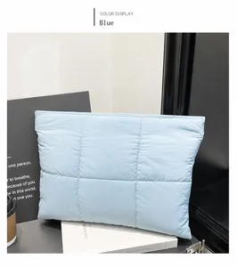 Detail view of light blue quilted down laptop sleeve featuring soft puffer nylon fabric