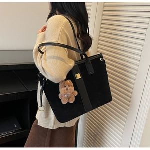 Large black tote bag in matte suede with leather straps and a brown plush bear charm