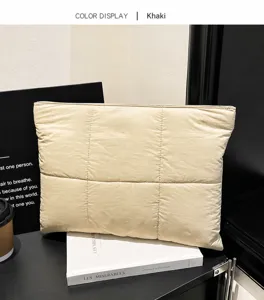 Close-up of khaki quilted nylon pouch with square stitching and top zipper detail