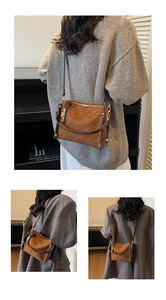 Close-up of quilted pattern and top handle on retro brown faux leather crossbody bag