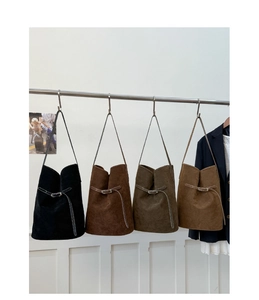 Plusieurs sacs seaux en cuir mat de couleurs noir, marron foncé, vert et chameau