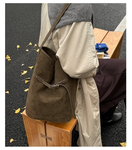 Détail du sac seau marron mat avec cordon réglable sur fond de rue automnale pittoresque