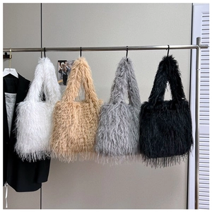 Multiple colors of plush tote bags including white, khaki, grey and black hanging in display