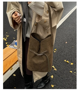Gros plan du sac seau en daim marron avec boucle en métal sur fond de rue d'automne