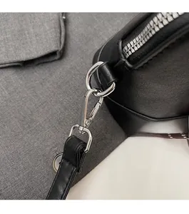 Gros plan des crochets en métal poli et des bandoulières en cuir noir d'un sac chic