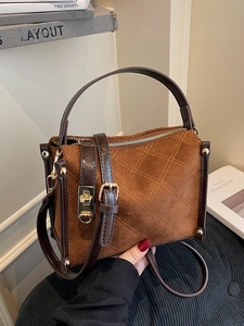 Brown quilted suede handbag with gold hardware and leather handles in a retro style
