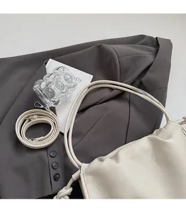 Detail of creamy white pebble leather texture and silver hardware on a shoulder bag