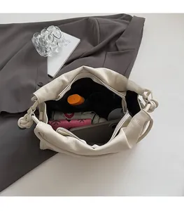 Interior view of large capacity cream shoulder bag with umbrella and wallet stored inside