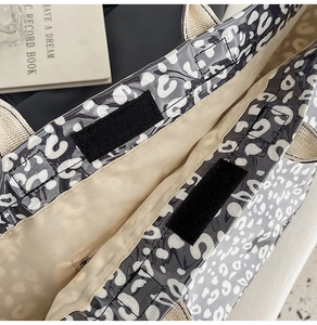Detail of leopard print tote bag showing velcro closure and inner zipper pocket texture