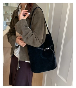 Détail du sac seau en daim noir avec boucle argentée et grand design vintage