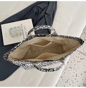 Interior detail of large leopard print tote bag showing spacious lining and zipper pocket